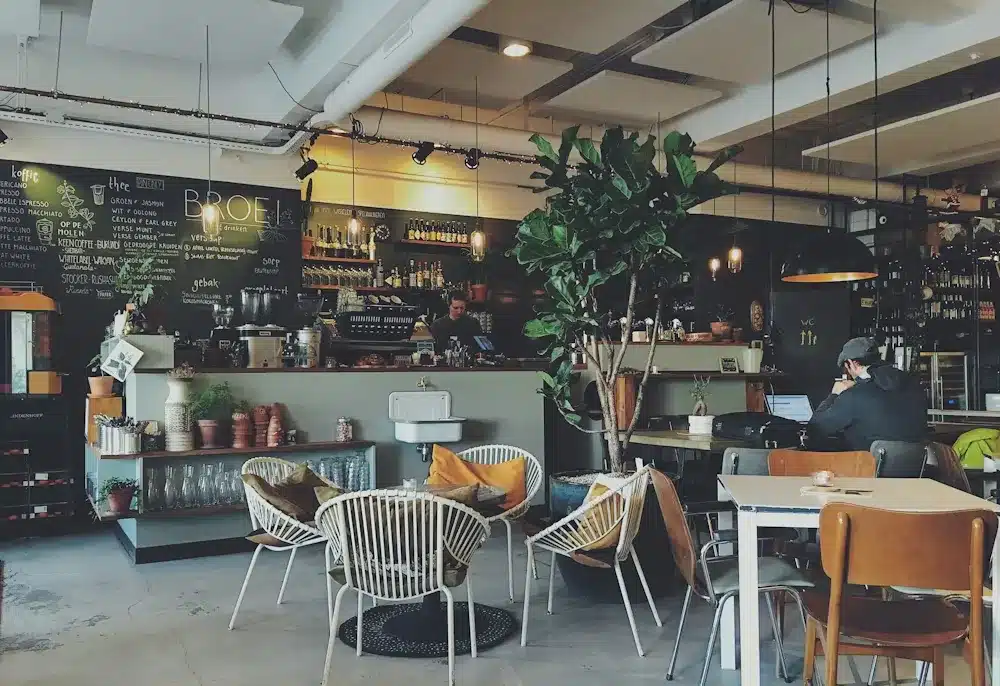 Barista serving coffee to a returning customer at a neighbourhood cafe